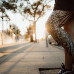 Red Arbor Tattoo - Japanese-inspired leg sleeve tattoo featuring chrysanthemum flowers and waves. Black and gray work by Red Arbor Tattoo.