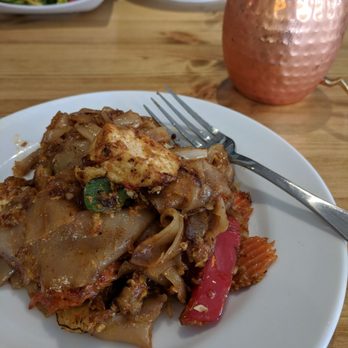 Kin'd - Drunken noodles with tofu in the foreground, spicy basil fried rice, lychee Thai tea, and edamami in the background. - Thai Near Me - Fresh Meadows, New York