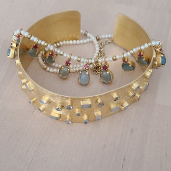 Manjusha Jewels - A gold vermeil moonstone studded bracelet with a topaz, pearl, and garnet necklace draped on top - Jewelry Near Me - Concord, California Manjusha Jewels - A gold vermeil moonstone studded bracelet with a topaz, pearl, and garnet necklace draped on top - Jewelry Near Me - Concord, California