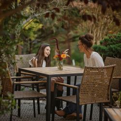 Lookout Mountain Inn - Guests seated at an outdoor patio table at Lookout Mountain Inn, surrounded by trees and garden greenery.