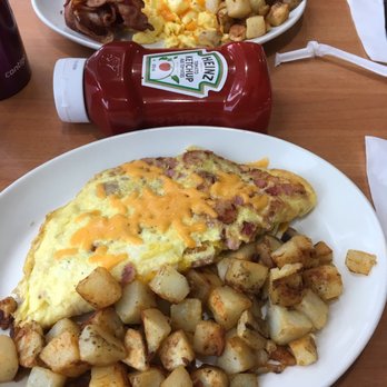 Sunset Grill - Meat lovers omelette in foreground and French connection in the back. Ketchup bottle for size comparison. - Diners Near Me - St. Catharines, Ontario Sunset Grill - Meat lovers omelette in foreground and French connection in the back. Ketchup bottle for size comparison. - Diners Near Me - St. Catharines, Ontario