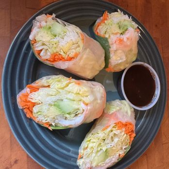 Thai Table & Kitchen - Summer rolls. (my own plating, hold the chicken) - Four spring rolls filled with lettuce, carrots, and cucumbers are arranged on a dark plate with a small cup of dipping sauce. - Thai Near Me - Pittsburgh, Pennsylvania