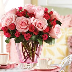 Angela's Floral Studio - A stunning bouquet of pink roses and red spray roses elegantly arranged in a pink glass vase...