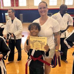 Family Kicks Championship Martial Arts - Proud Mama at Promotion Ceremony for this kid. Red Belt = Advanced status