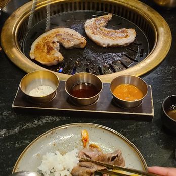 MOA Korean BBQ & Bar - Pork belly cooking. Polishing off some brisket, rice, scallion salad, seaweed salad, and pickled squash on my plate! - Barbeque Near Me - Charlotte, North Carolina