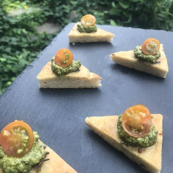 Harvest & Revel - Housemade flatbread with vegan pesto and seasonal cherry tomatoes, served as passed bites in a garden for a beautiful wedding reception - Caterers Near Me - Brooklyn, New York Harvest & Revel - Housemade flatbread with vegan pesto and seasonal cherry tomatoes, served as passed bites in a garden for a beautiful wedding reception - Caterers Near Me - Brooklyn, New York