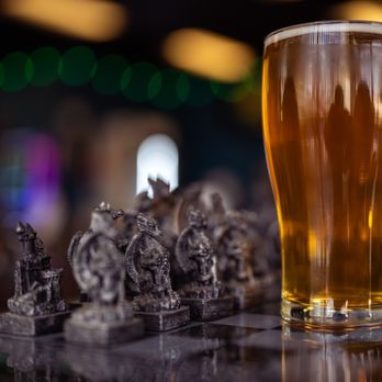Dragon's Tale Brewery - a glass of beer and chess pieces - Breweries Near Me - Montclair, California Dragon's Tale Brewery - a glass of beer and chess pieces - Breweries Near Me - Montclair, California