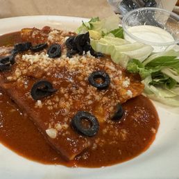 2 cheese enchiladas with red sauce sour cream and lettuce.