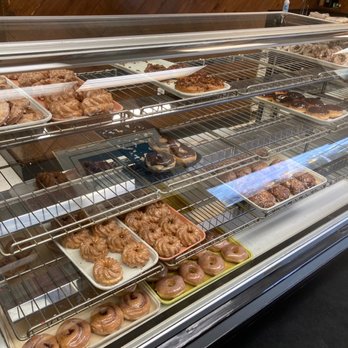 Spudnut Donuts - A glass display case showcases an assortment of donuts and pastries, including glazed, chocolate-topped, and filled varieties, in a bakery or donut shop setting. - Donuts Near Me - Berea, Ohio