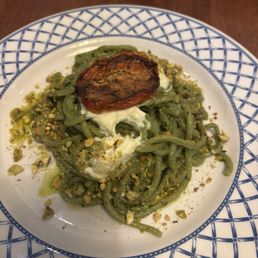 Bucatini pasta with basil pistachio pesto Topped with a roasted tomato.