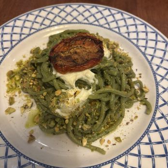 Seppia - Bucatini pasta with basil pistachio pesto Topped with a roasted tomato. - Italian Near Me - Baltimore, Maryland