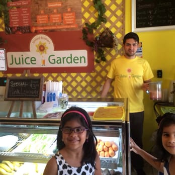 Juice Garden - a woman and two children in front of a juice garden - Juice Bars & Smoothies Near Me - Astoria, New York