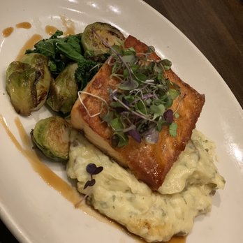 Salt Creek Grille - Salmon over mashed potato  with a ponzu drizzle and a side of bacon Brussels sprouts - New American Near Me - Rumson, New Jersey
