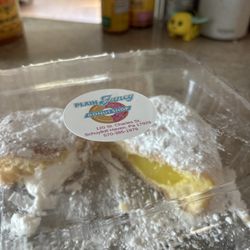 Plain & Fancy Donut Shop - Yummy Lemon and white cream filled half gone donuts!