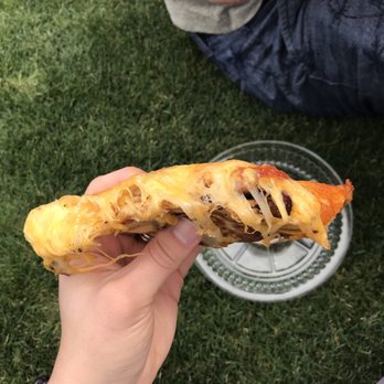 Rolled Quesadillas - a person holding a piece of quesadilla - Food Trucks Near Me Rolled Quesadillas - a person holding a piece of quesadilla - Food Trucks Near Me