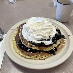 a stack of pancakes topped with whipped cream a stack of pancakes topped with whipped cream