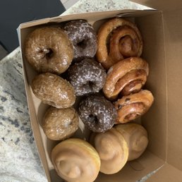 Dozen donuts. Blueberry and chocolate cake donuts. Maple cinnamon glazed, and cinnamon apple roll donuts. All delicious! Dozen donuts. Blueberry and chocolate cake donuts. Maple cinnamon glazed, and cinnamon apple roll donuts. All delicious!