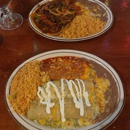 Front plate: 2 chicken enchiladas and 1 pork tamale Back plate: Steak rancheros Front plate: 2 chicken enchiladas and 1 pork tamale Back plate: Steak rancheros