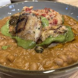 Rae’s - Herb grilled chicken thigh, white bean ragu, arugula pesto, grilled cauliflower, and sun dried tomato butter entree.
