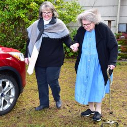 Envoy America - Companion Driver helping a client with a cane to their car.
