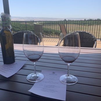 Pepper Bridge Winery - Walla Walla Valley - Patio with wine tasting menu and a wine bottle filled with water. Nice touch. - Wine Tasting Room Near Me - Walla Walla, Washington