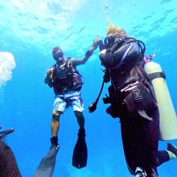 Manta Divers - Dive Instructor Vicente helping a diver maintain depth with an SMB during a Safety Stop