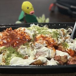 Chicken over rice with white sauce, green sauce, and hot sauce. Chicken over rice with white sauce, green sauce, and hot sauce.