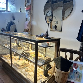 Luna and Luz - A glass jewelry display case showcases necklaces, rings, and bracelets in a boutique shop setting, with decorative mirrors and accessories nearby. - Jewelry Near Me - Albuquerque, New Mexico