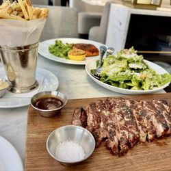 RH Rooftop Restaurant at RH Minneapolis - ribeye steak, truffle fries, Caesar salad, and salmon
