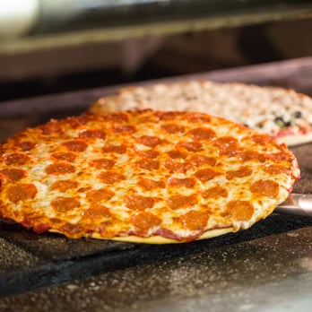 Beggars Pizza - a pizza being cooked in an oven - Pizza Near Me - New Lenox, Illinois