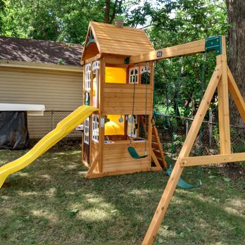 Swingset Dr's - a wooden swing set with a yellow slide - General Contractors Near Me Swingset Dr's - a wooden swing set with a yellow slide - General Contractors Near Me