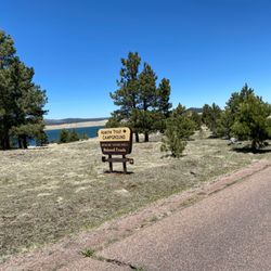 Apache Trout Campground - Big Lake behind the Apache Trout Campground sign