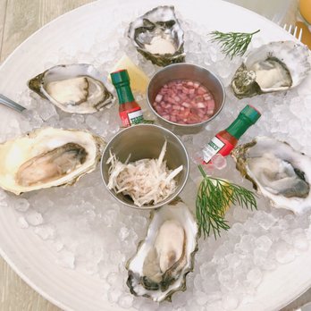 Driftwood Kitchen - Oysters Doz. Look at the mini tabasco sauce they have! | IG: happyfoodieoc - Seafood Near Me - Laguna Beach, California