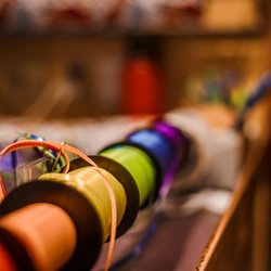 The Great Rocky Mountain Toy Company - Colorful spools of ribbon displayed inside a creative toy and gift store, featuring bright shades ideal for crafts, decoratin...