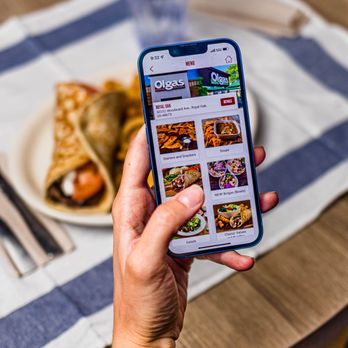 Olga's Kitchen - a person taking a picture of a meal - Salad Near Me - Monroe, Michigan