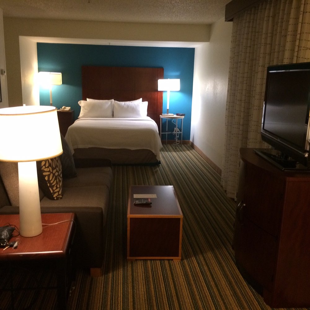 Residence Inn Phoenix - As you walk in you a nice bed. The living space & with TV, a gas fireplace & a desk to the right. - Hotels Near Me - Phoenix, Arizona Residence Inn Phoenix - As you walk in you a nice bed. The living space & with TV, a gas fireplace & a desk to the right. - Hotels Near Me - Phoenix, Arizona