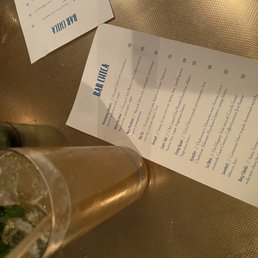 a menu and a drink on a table