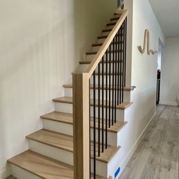 White oak lightly stained with black metal balusters and white risers. White oak lightly stained with black metal balusters and white risers.