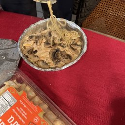 a bowl of noodles and a container of mushrooms