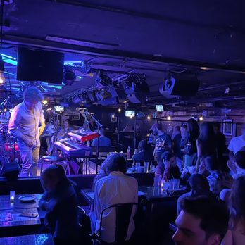 Cafe Wha? - a band performing on stage - Music Venues Near Me - New York, New York