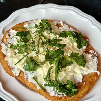 Titusz - LANGOS - Fried potato bread topped with topten, goat gouda, herbs - Hungarian Near Me - Pittsburgh, Pennsylvania Titusz - LANGOS - Fried potato bread topped with topten, goat gouda, herbs - Hungarian Near Me - Pittsburgh, Pennsylvania