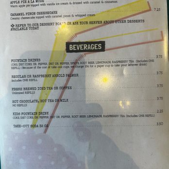 El Milagro - a menu for desserts - The menu page is divided into sections for desserts and beverages. Desserts include apple pie a la mode and caramel pinon cheesecake, with a note to ask the server about other options. Beverages listed include fountain drinks, raspberry Arnold Palmer, iced tea, coffee, hot chocolate, milk, kids' fountain drink, and soda. Prices are provided for each item, and some items have additional details about refills or ingredients. The menu is printed on paper with some highlighted or marked text. - New Mexican Cuisine Near Me - Santa Fe, New Mexico