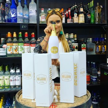 A5 LIQUORS - a woman holding a bottle of alcohol - Beer, Wine & Spirits Near Me - Miami, Florida