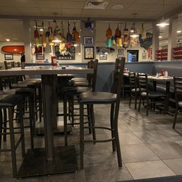 The image shows the interior of a seafood restaurant featuring nautical-themed decorations, including hanging buoys. There are tables and chairs arranged for dining, with some tables set with condiments.
