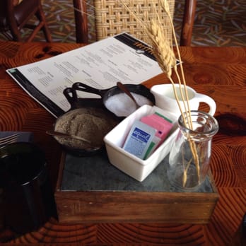 Solstice - a table with a glass of water, a book, and a pair of sunglasses - New American Near Me - Stowe, Vermont