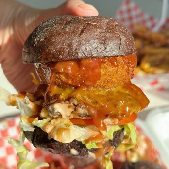 Astro Sliderz - a hand holding up a burger - Food Trucks Near Me - Kissimmee, Florida
