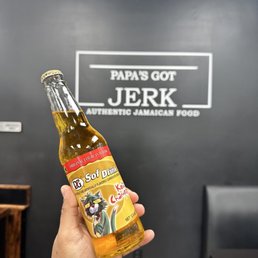 a hand holding a bottle of beer a hand holding a bottle of beer