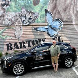 Justin's Taxi Service  - Justin himself parked in front of the iconic Bartow mural with the sleek black Cadillac from Justin's Taxi