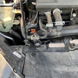 Sun Devil Auto - Lid to bottle of oil left in car (in front of orange/red tab)