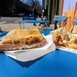 Welcome Home - Mortadella and Cheese and an Almond croissant on their sidewalk tables.